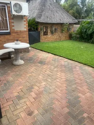 a brick patio with a picnic table and a building at Cozy Garden Flat with Garden in Pretoria