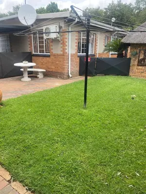 a yard with a table and a basketball hoop at Cozy Garden Flat with Garden in Pretoria