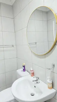 a white bathroom with a sink and a mirror at HMT Exquisite Spaces in Polokwane