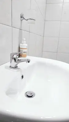 a white bathroom sink with a faucet on it at HMT Exquisite Spaces in Polokwane