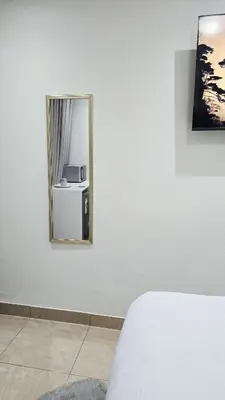 a bedroom with a mirror on a white wall at HMT Exquisite Spaces in Polokwane