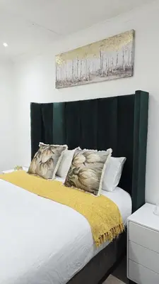 a bedroom with a bed with a black headboard at HMT Exquisite Spaces in Polokwane