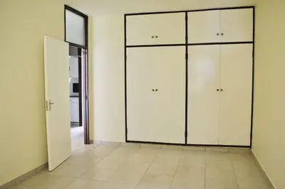 an empty room with white cabinets and a tile floor at Heideland in Pretoria