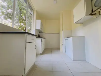 a kitchen with white appliances and a large window at Heideland in Pretoria