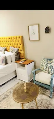a living room with a couch and a table and a chair at Menlyn Main Apartments Trilogy in Pretoria