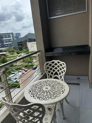 a balcony with a table and chairs on a balcony at Menlyn Main Apartments Trilogy in Pretoria