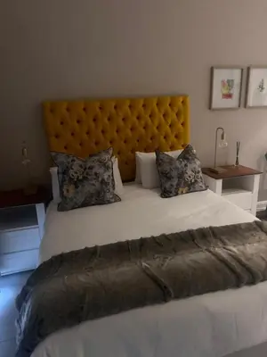 a large bed with a large headboard in a bedroom at Menlyn Main Apartments Trilogy in Pretoria
