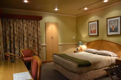 a bedroom with a bed and a desk and a table at The Lodge Bethal in Bethal