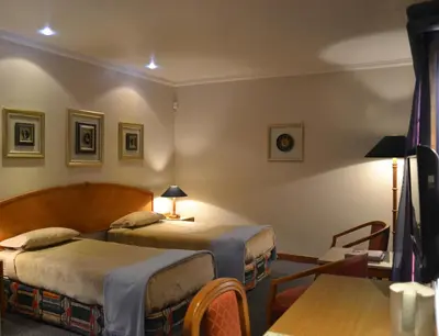 a hotel room with two beds and a table at The Lodge Bethal in Bethal