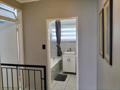 a bathroom with a bath tub and a sink at Rhodesfield's Hidden Gem in Kempton Park