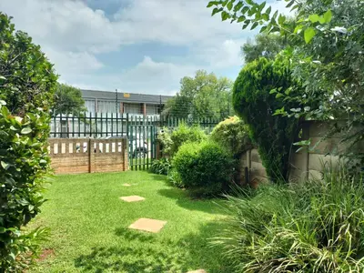 a garden with a fence and green grass at Rhodesfield's Hidden Gem in Kempton Park