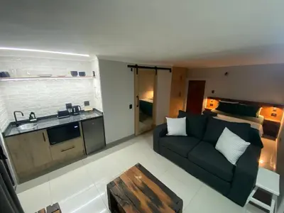 a living room with a couch and a kitchen at The Hideaway in Nelspruit