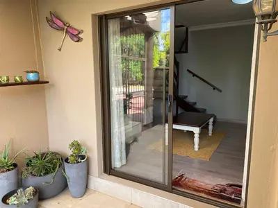 a glass door leading to a patio with potted plants at Baobab Guesthouse in Centurion