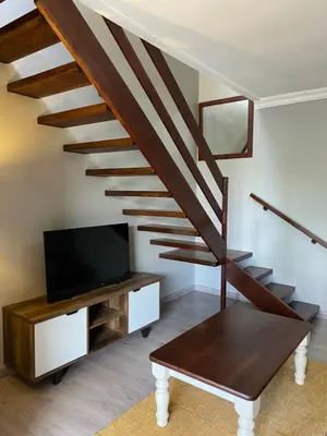 a living room with a staircase with a flat screen tv at Baobab Guesthouse in Centurion