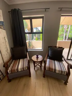 two chairs and a table in a room with a window at Baobab Guesthouse in Centurion