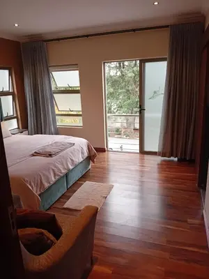 a bedroom with a bed and sliding glass doors at Gillian Place in Sandton