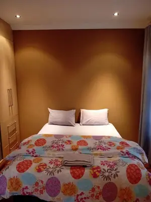 a bedroom with a large bed with flowers on it at Gillian Place in Sandton