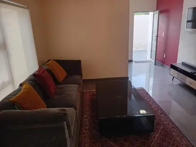 a living room with a couch with a laptop on it at Gillian Place in Sandton