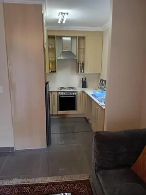 a kitchen with wooden cabinets and a stove at Gillian Place in Sandton