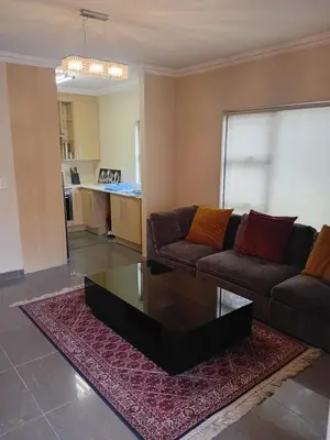 a living room with a couch and a coffee table at Gillian Place in Sandton
