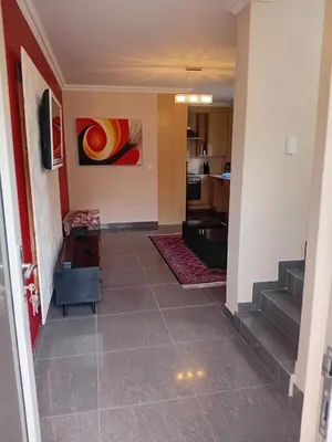 a hallway with a living room and a staircase at Gillian Place in Sandton