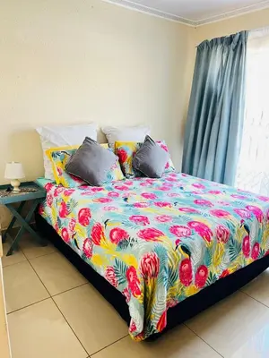 a bed with a colorful comforter in a bedroom at The Barberton Nest in Barberton