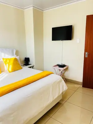 a bedroom with a large bed with a television on the wall at The Barberton Nest in Barberton