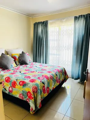 a bedroom with a bed with a colorful blanket at The Barberton Nest in Barberton