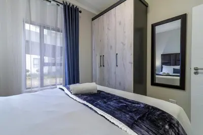 a bedroom with a large bed and a mirror at Ground Floor Premium Suite in Midrand