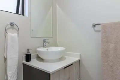 a bathroom with a white sink and a mirror at Ground Floor Premium Suite in Midrand