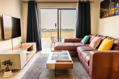 a living room with a couch and a table at Infinite Views Penthouse in Midrand