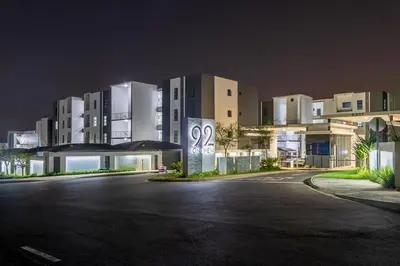 a building at night with a parking lot in front at Infinite Views Penthouse in Midrand