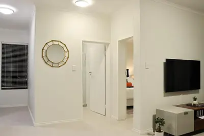 a white room with a television and a bedroom at Infinite Views Penthouse in Midrand