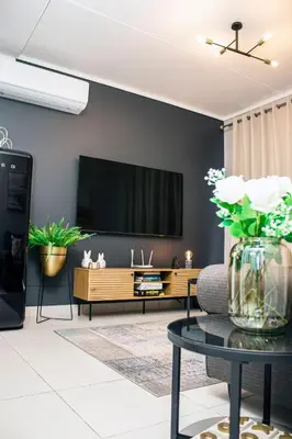 a living room with a tv on a wall at Green Valley Apartment in Boschrand