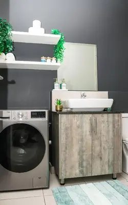a bathroom with a washing machine and a sink at Green Valley Apartment in Boschrand