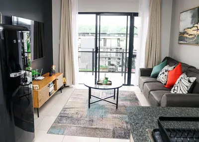 a living room with a couch and a table at Green Valley Apartment in Boschrand