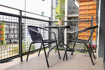 two chairs and a table on a balcony at Green Valley Apartment in Boschrand