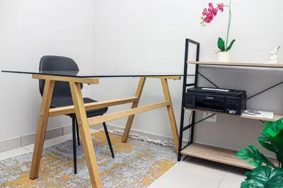 a desk with a chair and a table with a printer at Green Valley Apartment in Boschrand