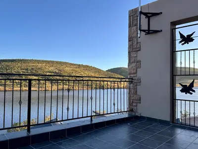 a balcony with a view of a body of water at Fish Eagle Manor in Warmbaths