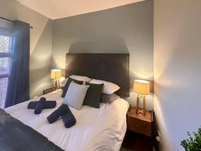 a bedroom with a large bed with two lamps at Fish Eagle Manor in Warmbaths