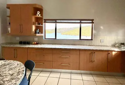 a kitchen with wooden cabinets and a window in it at Fish Eagle Manor in Warmbaths