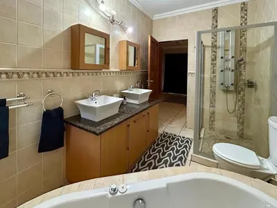 a bathroom with a tub and two sinks and a shower at Fish Eagle Manor in Warmbaths