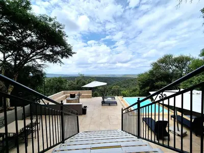 a balcony with a view of a swimming pool at Lovely family home in the bush in Warmbaths