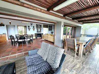 a living room and dining room with a table and chairs at Lovely family home in the bush in Warmbaths