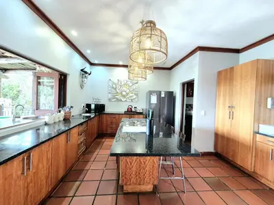 a large kitchen with a large black counter top at Lovely family home in the bush in Warmbaths