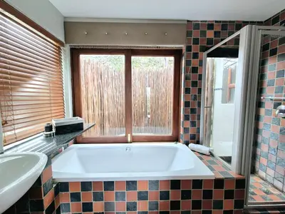 a bathroom with a large tub and a window at Lovely family home in the bush in Warmbaths
