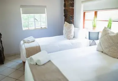 a room with two white beds and a window at Silverlakes Farm Hotel in Pretoria