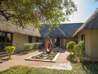 a house with a sign in front of it at Kokobela Lodge in Phalaborwa