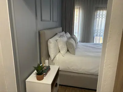 a bedroom with a bed with white pillows and a window at 191 Protea Estate in Midrand