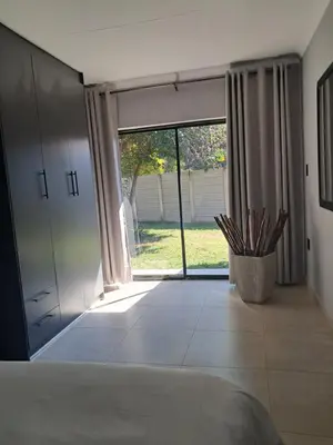 a bedroom with a large sliding glass door to a yard at Adam's Inn place in Hartbeespoort